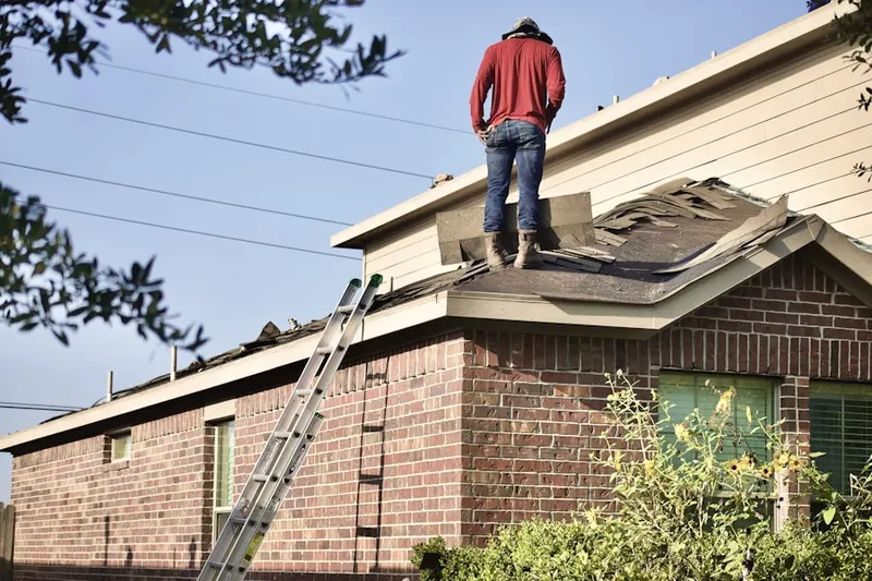 Professional roofer working on a residential roof in Hampden